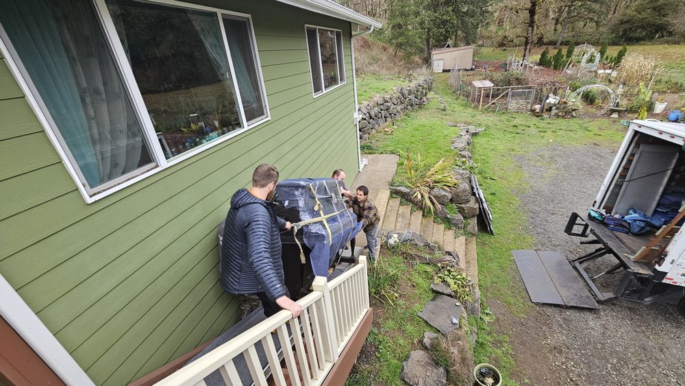 Easier Moving crew rolling a piano across a residential deck