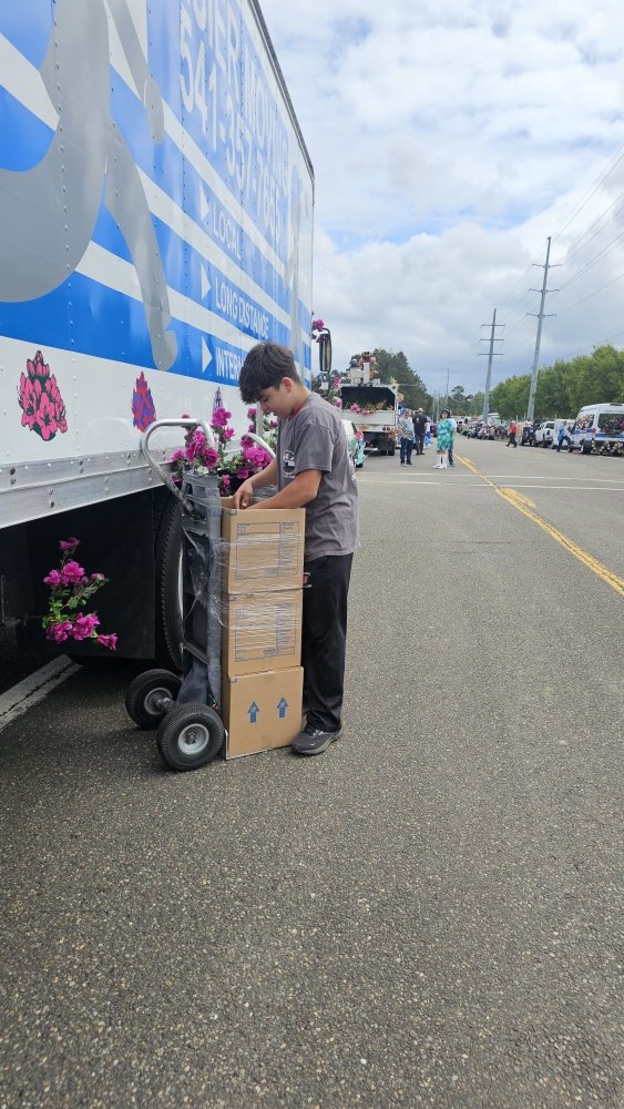 Helper wheeling boxes at the parade