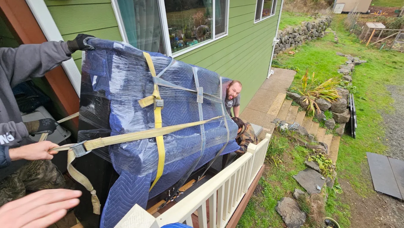 Strapped hot tub coming off a deck rail on moving straps