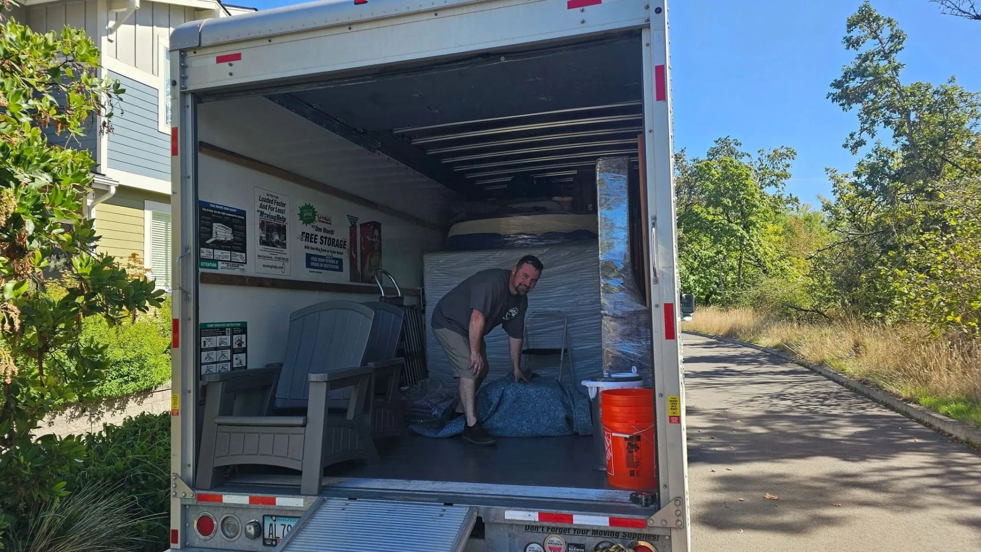 Mover laying blankets over a load inside the truck